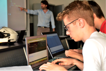 Ragazzo osserva lo schermo di un computer mentre segue il corso estivo steam su coding al Politecnico di Milano
